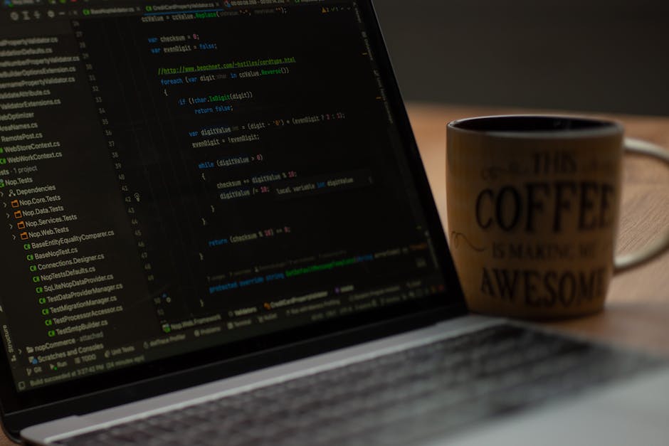 A close-up view of a laptop screen displaying lines of code in a text editor, with a focus on the programming syntax highlighted in various colors such as green, yellow, and blue. To the right of the 
